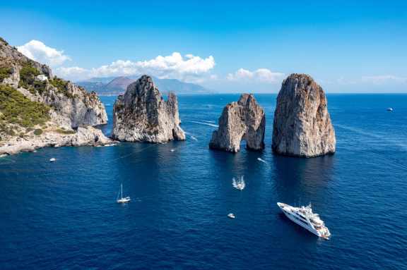 Top Amalfi Coast yacht charter destinations, the Faraglioni Rocks in Capri Island along the Amalfi Coast. From Swimming around the rocks to the beautiful sunset, enjoy Faraglioni Rocks to the fullest.